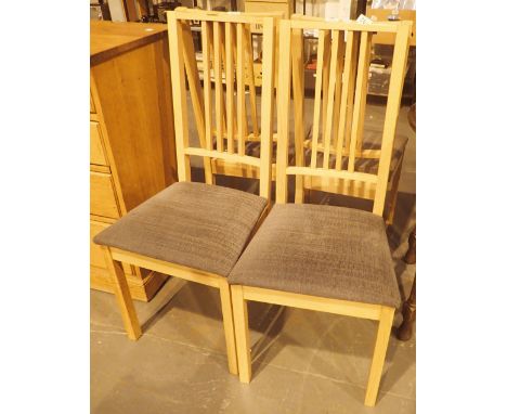 Four light wood dining chairs with upholstered seats