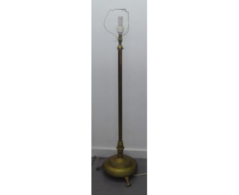 A BRASS STANDARD LAMP, THE COLUMN ADJUSTABLE FOR HEIGHT ON HEAVY CIRCULAR BASE, RAISED ON FEET AND THE SILK SHADE 