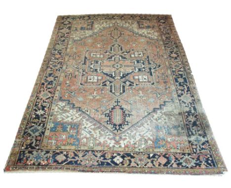 FINE ANTIQUE PERSIAN HERIZ CARPET, 322cm x 214cm, circa 1910, central medallion on coral field of stylised vines and palmette