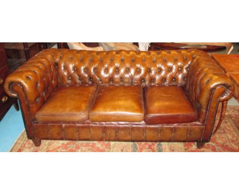 CHESTERFIELD SOFA, with curved deep button back and arms in faded tan brown leather, three cushions, 195cm W.