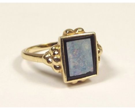 OPAL RING.
A 10k., square cut opal doublet ring. Size M/N.