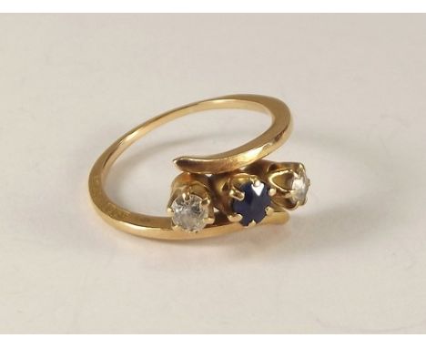 AMERICAN RING.
An 18ct. gold, sapphire & diamond cross over ring, the side of the shank stamped 18ct. & KOH? Size Q/R.