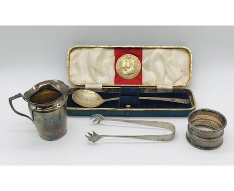 A small hallmarked silver jug, silver Coronation spoon and napkin ring along with a pair of silver plated sugar nips