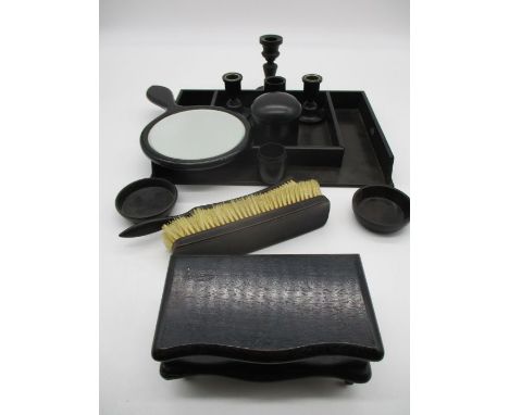 A collection of ebony dressing table pots, hand mirror etc.