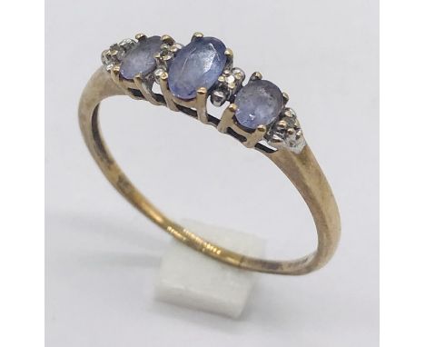 An amethyst three stone ring with small diamonds set in 9ct gold