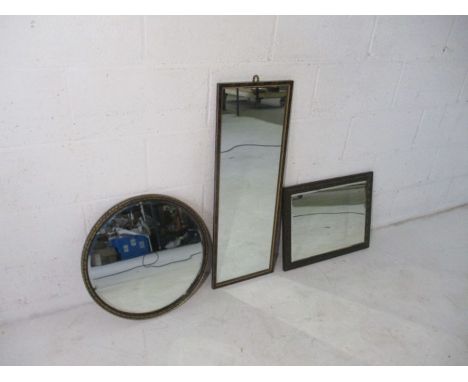 An embossed brass mirror, along with two others