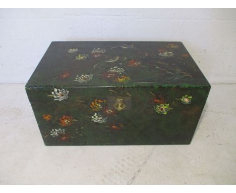 A painted trunk, depicting ornate birds and flowers, with brass handles.
