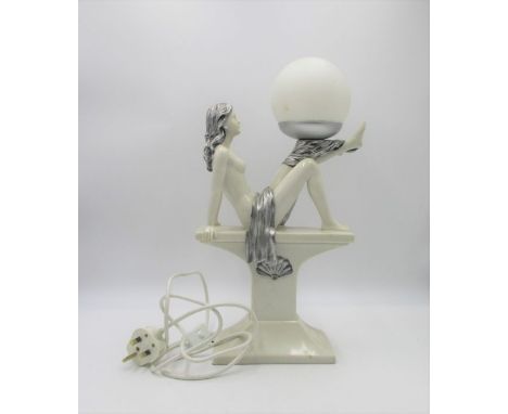 An Art Deco style lamp, in the form of a lady sitting on a plinth.