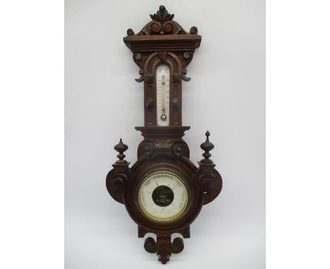 An Edwardian barometer in carved case with thermometer above 