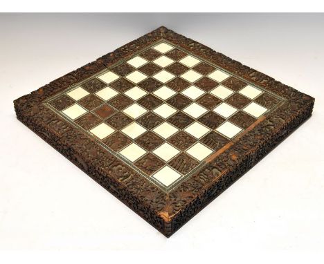 Late 19th Century Indian (Vizagapatam) ivory-mounted carved wooden chess board, having thirty-two ivory squares and thirty-tw