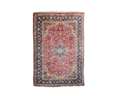 Middle Eastern (South Persian) wool carpet, the madder rose field with central floral and foliate medallion within similar mo