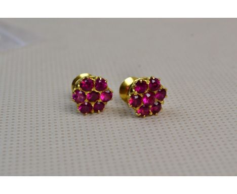 A pair of ruby cluster earrings, circular, in claw mounts to posts with screw fittings