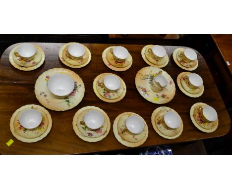 A Royal Worcester twelve place tea service, hand decorated with spring and summer flowers on a blush ivory and gilt ground, n