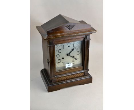 An Edwardian oak mantel clock, the architectural case enclosing an eight-day gong striking movement, faced by silvered Arabic