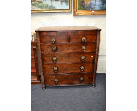 An early 19th century step bow fronted mahogany chest of two short over four long drawers 