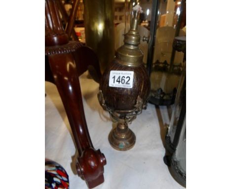 An unusual brass oil lamp the font being a coconut shell