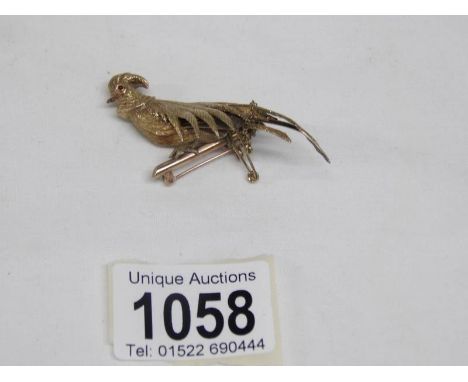 A 14ct fold bird of paradise on 9ct gold bar with cabachon cut ruby eyes, 8.26gms