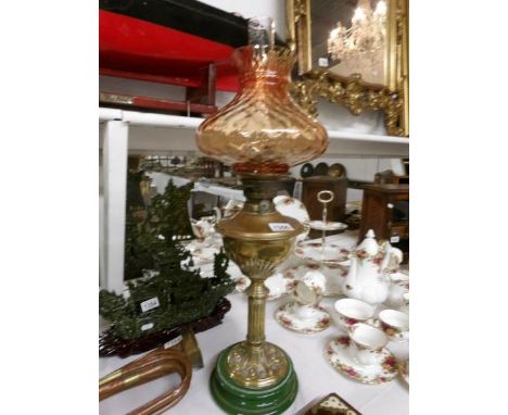 An oil lamp on pot base and with brass column, complete with shade and chimney