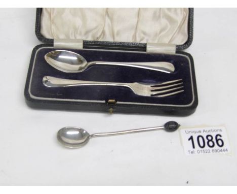 A cased silver spoon with fork and a silver coffee spoon