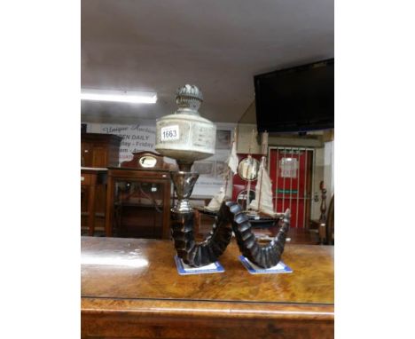 A unusual oil lamp with metal rams horn base