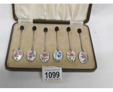 A cased set of 6 silver and enamel coffee spoons with floral decoration