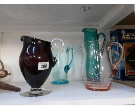 4 vintage coloured glass jugs, one marked Dartington