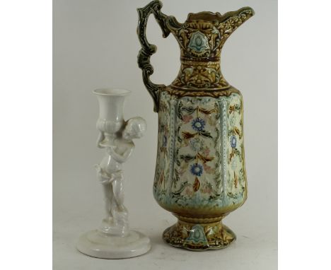 A Continental pottery ewer with ornate scrolling foliate relief deco and a continental pottery white ground candle stick in t