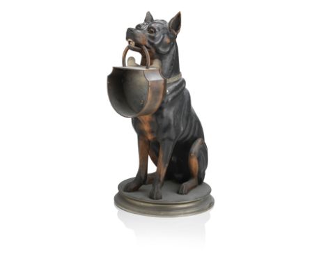 An early 20th century carved and polychrome decorated figure of a black and tan terrierWith glass eyes, seated whilst holding