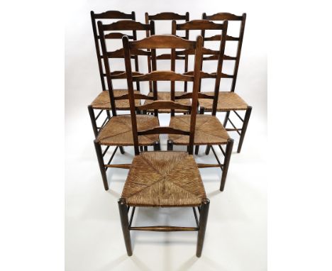 A set of six stained beech ladder back chairs, with rush seats, 109cm high x 44cm wide x 43cm high  