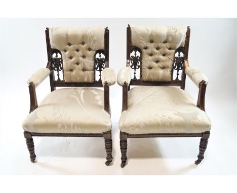 A pair of Victorian mahogany and button back armchairs with turned legs on casters, 86cm high x 60cm wide x 58cm deep