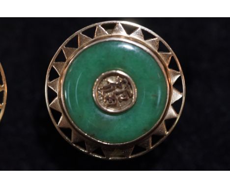 A yellow metal pair of circular cufflinks. Set with a commercial green jade and finished to the centre with a Chinese symbol.