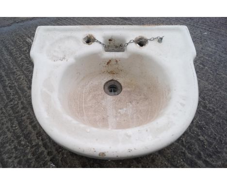 A glazed stoneware wash hand basin of half round form, set with an indented soap reserve, (sold by order of the Community and
