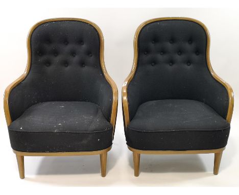 A pair of mid 20th century style armchairs with oak show frames upholstered in black with button backs on turned tapering leg