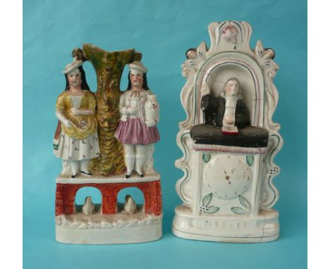 A colourful Staffordshire pottery group of two females standing upon a bridge with swans beneath, circa 1850. 265mm, swans an