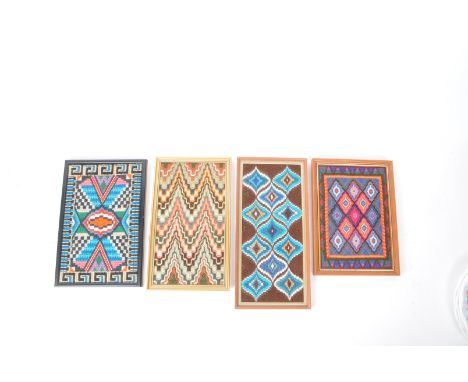 A collection of four vintage 20th century needlework sampler panels. Each featuring polychrome geometric patterning. The four