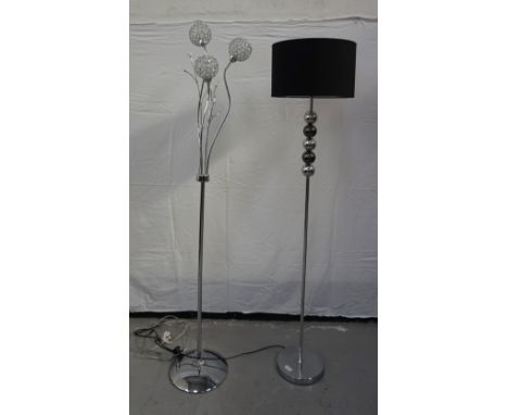CONTEMPORARY BRUSHED STEEL STANDARD LAMPraised on a circular base with a turned column with five spheres below a black shade,
