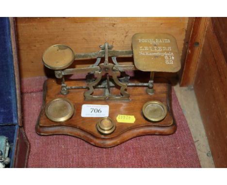 A set of brass postal scales and weights