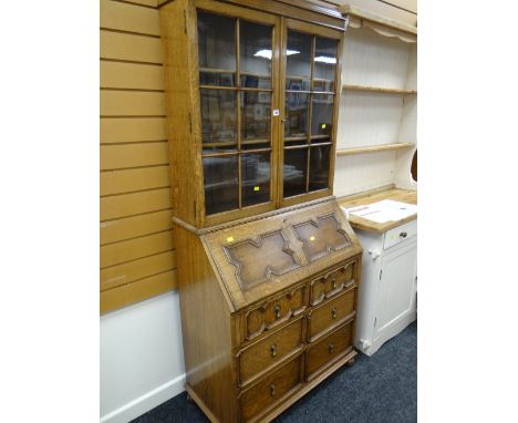 A reproduction Jacobean-style light oak bureau bookcase