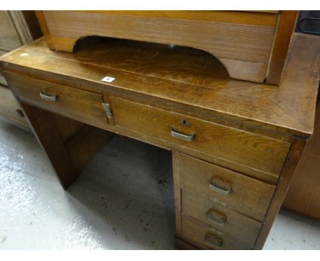 A vintage writing desk with a bank of four short & two knee high drawers