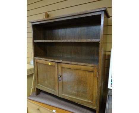 A vintage oak adjustable bookcase with cupboard below
