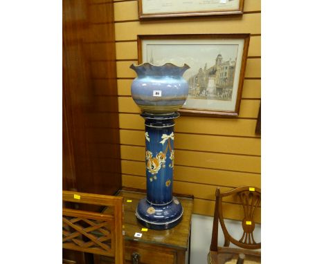 A pottery planter on a floral painted pottery pedestal
