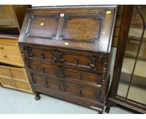 A vintage oak Jacobean-style three-drawer sloped bureau