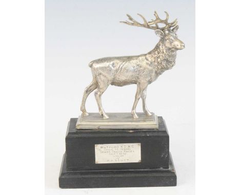 A George V white metal trophy, modelled as a stag on a naturalistic base and ebonised stepped rectangular plinth with present