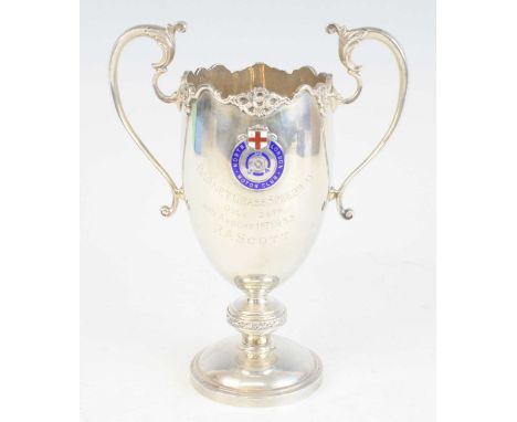 A George V. silver trophy cup, the shaped rim with cast border and acanthus capped twin C-scroll handles, having an enamel ba