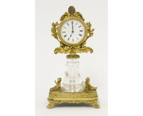 A Palais Royale rock crystal and ormolu desk timepiece, 19th century, the enamel dial framed by gilt wreaths and fruiting vin