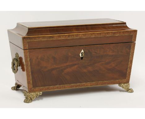 A figured mahogany tea caddy,c.1830, with strung and crossbanded decoration, the interior with two caddy boxes and cut glass 