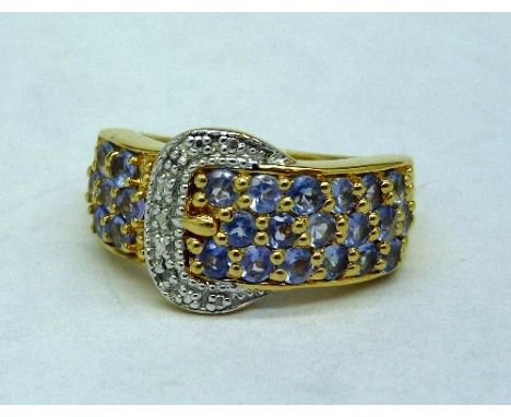 A silver gilt, tanzanite and diamond chip buckle ring, size O