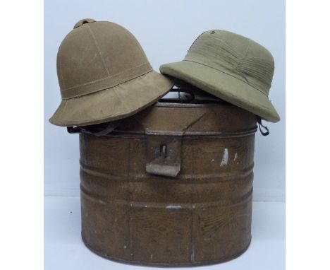 An Indian pith helmet and one other dated 1923 in a hat tin trunk