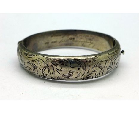 A silver bangle with inscription dated 1957