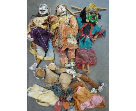 Three wooden puppets and clothing and one other puppet with two masks